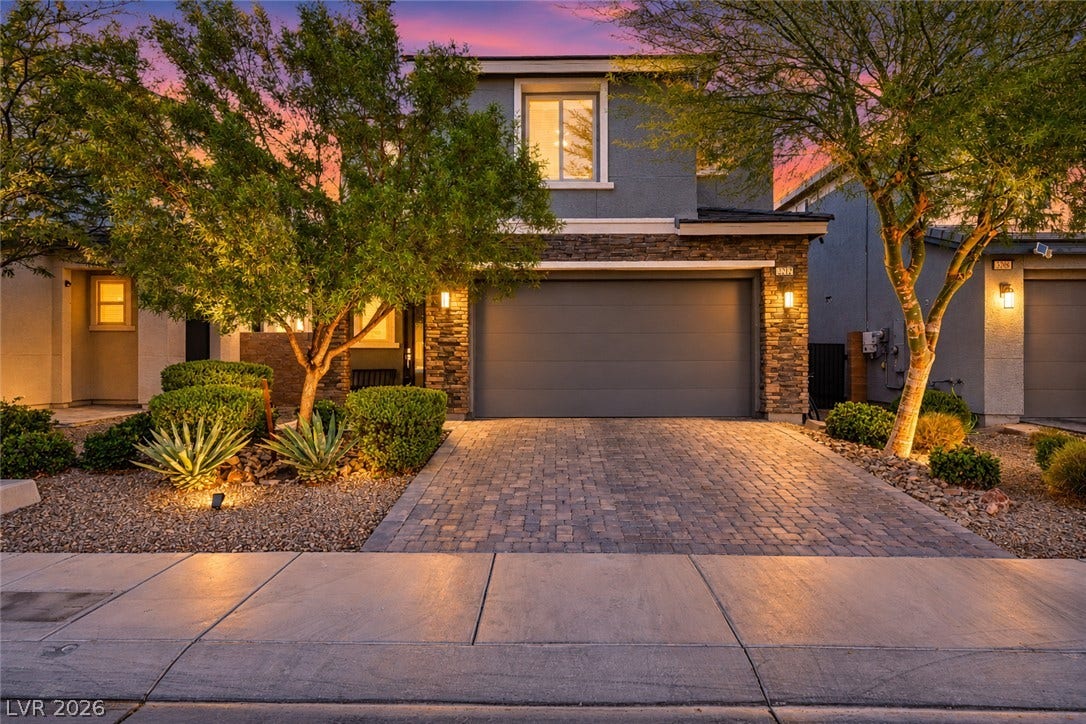 Stone accents and a paved driveway enhance the striking curb appeal of this modern home.