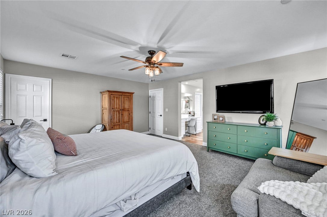 Plush carpeting anchors this spacious bedroom featuring clean lines and smooth neutral walls.