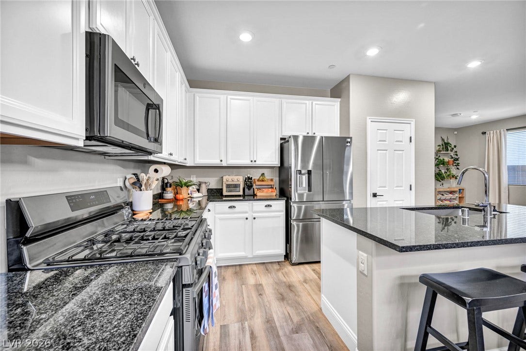 Gleaming stone countertops and modern appliances anchor this thoughtfully designed culinary workspace.