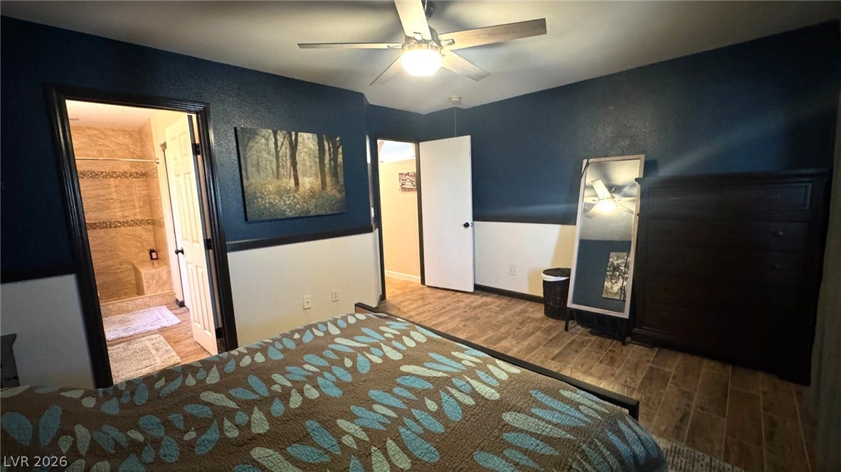 Gleaming wood-look tile floors and classic chair rail molding define this private primary suite.