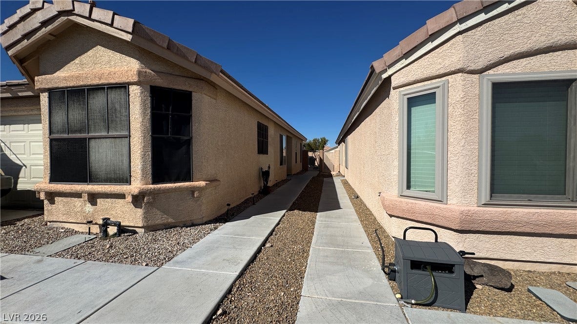 Neat concrete walkways guide the way along the exterior of these classic stucco homes.
