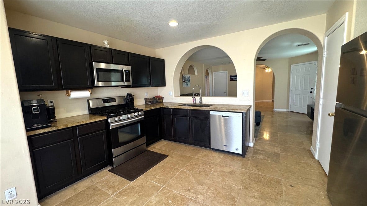 An arched pass-through window and classic tile flooring enhance this functional kitchen workspace.