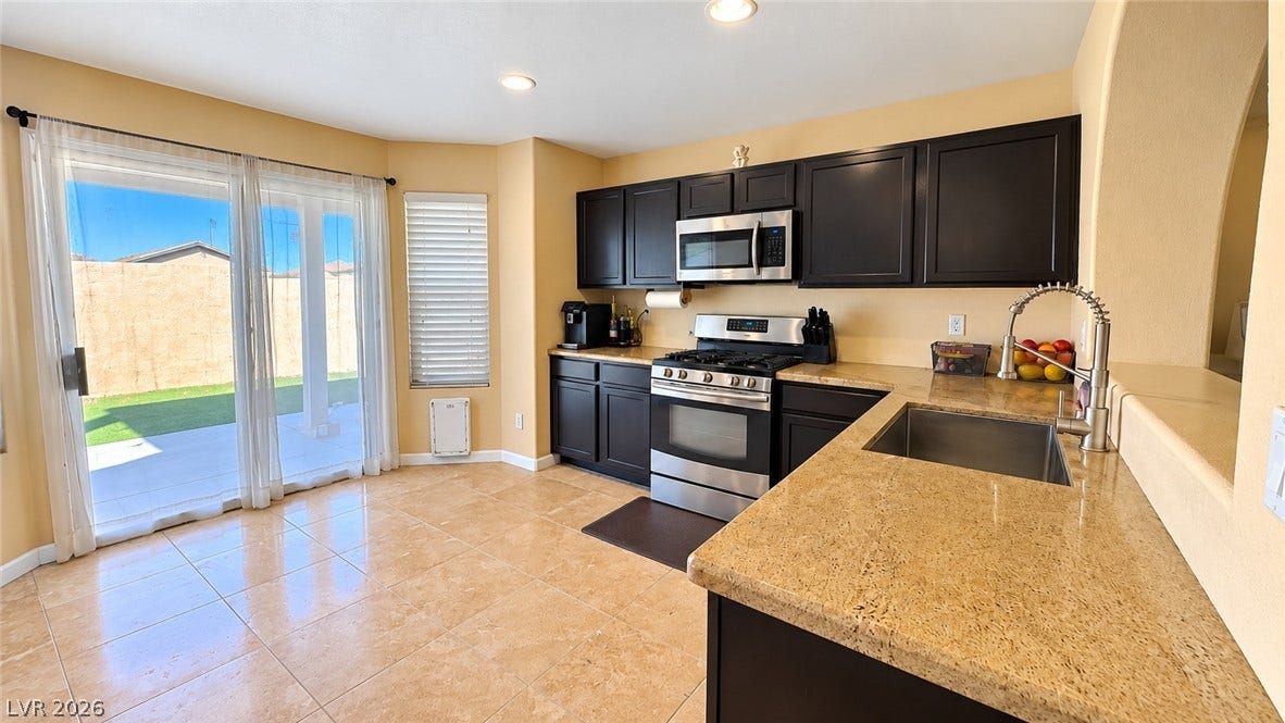Gleaming tile floors and granite countertops define this functional, open kitchen layout.