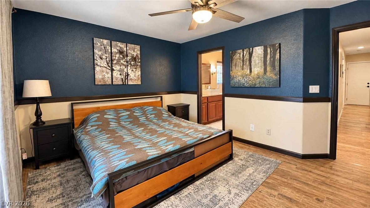 Rich wood-look flooring and custom wainscoting highlight this comfortable private retreat.