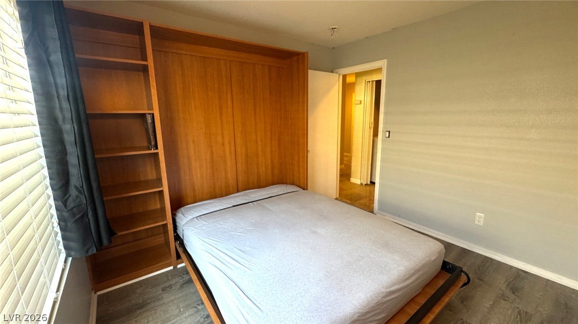 Functional built-in wood shelving and smooth floors anchor this versatile room.