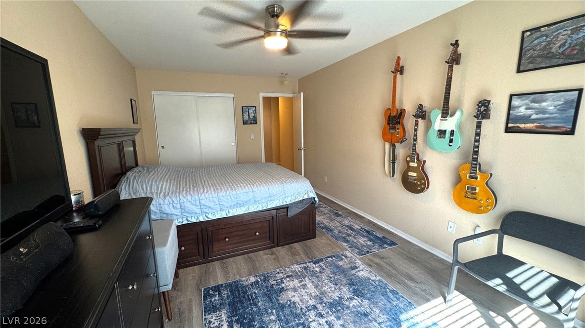 Gleaming wood-look flooring and built-in sliding closet doors define this comfortable secondary bedroom.