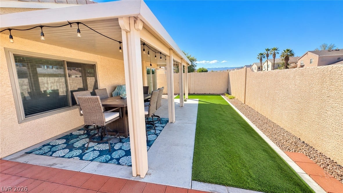 A spacious covered patio overlooks a private yard with neat landscaping.