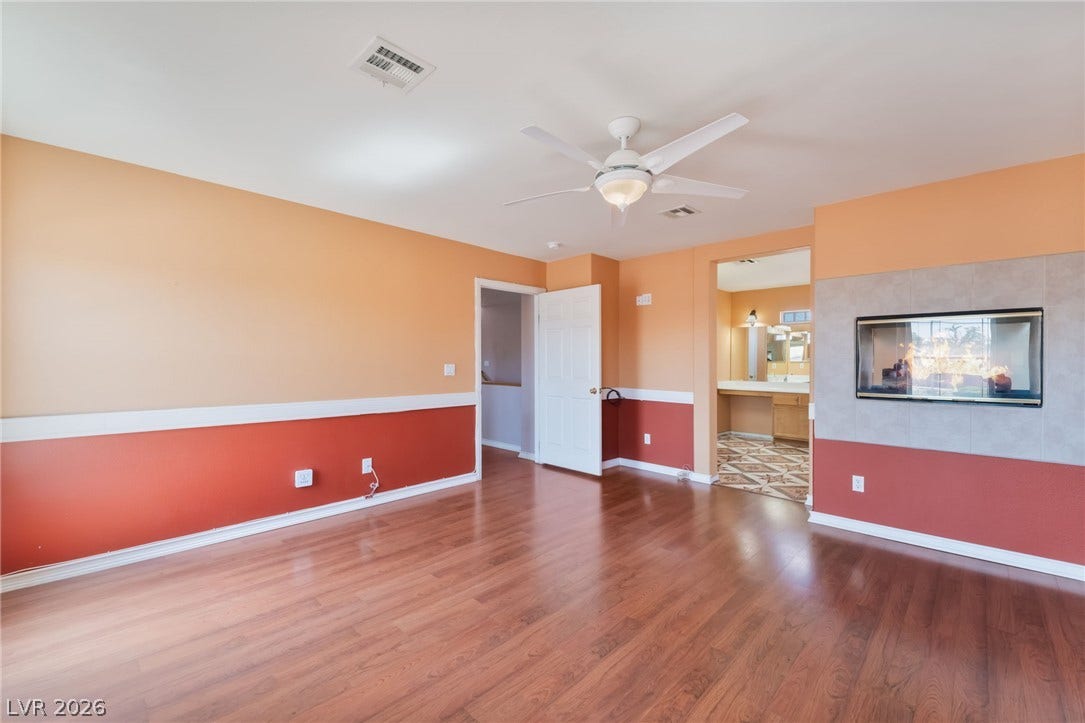Rich wood flooring anchors this versatile space featuring a built-in double-sided fireplace.
