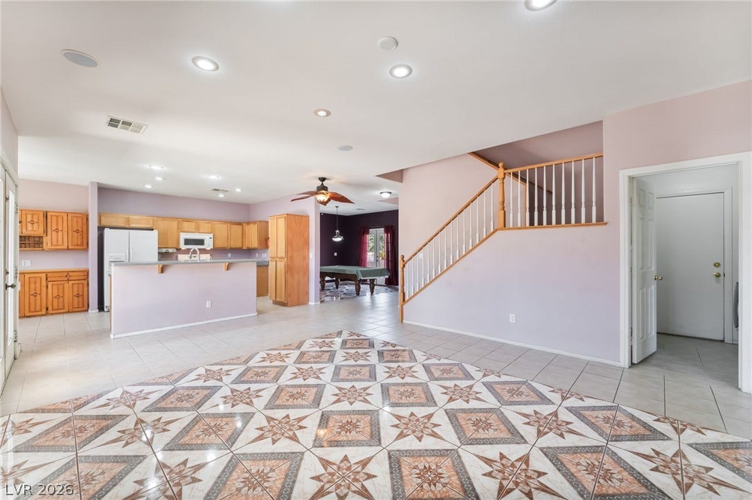 An open layout connects the tiled living space directly to the kitchen and staircase.