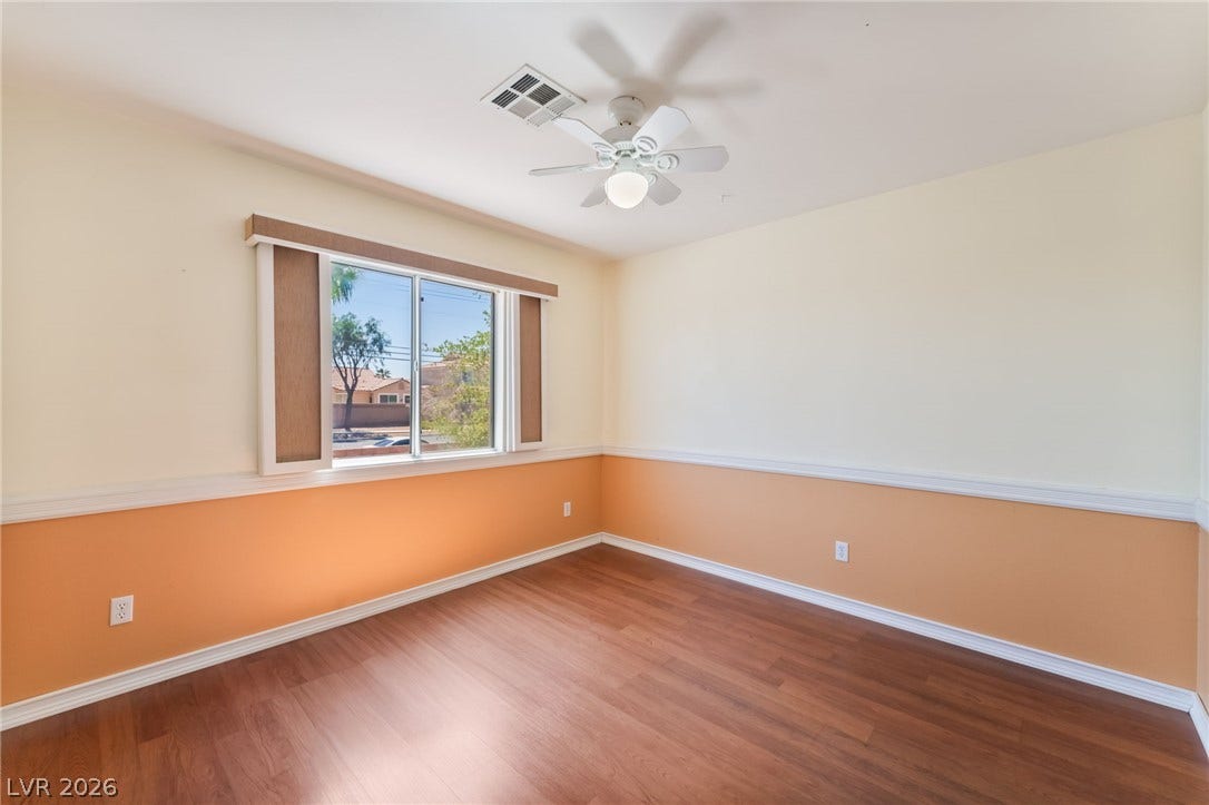 Rich wood flooring pairs elegantly with classic chair rail molding in this versatile room.