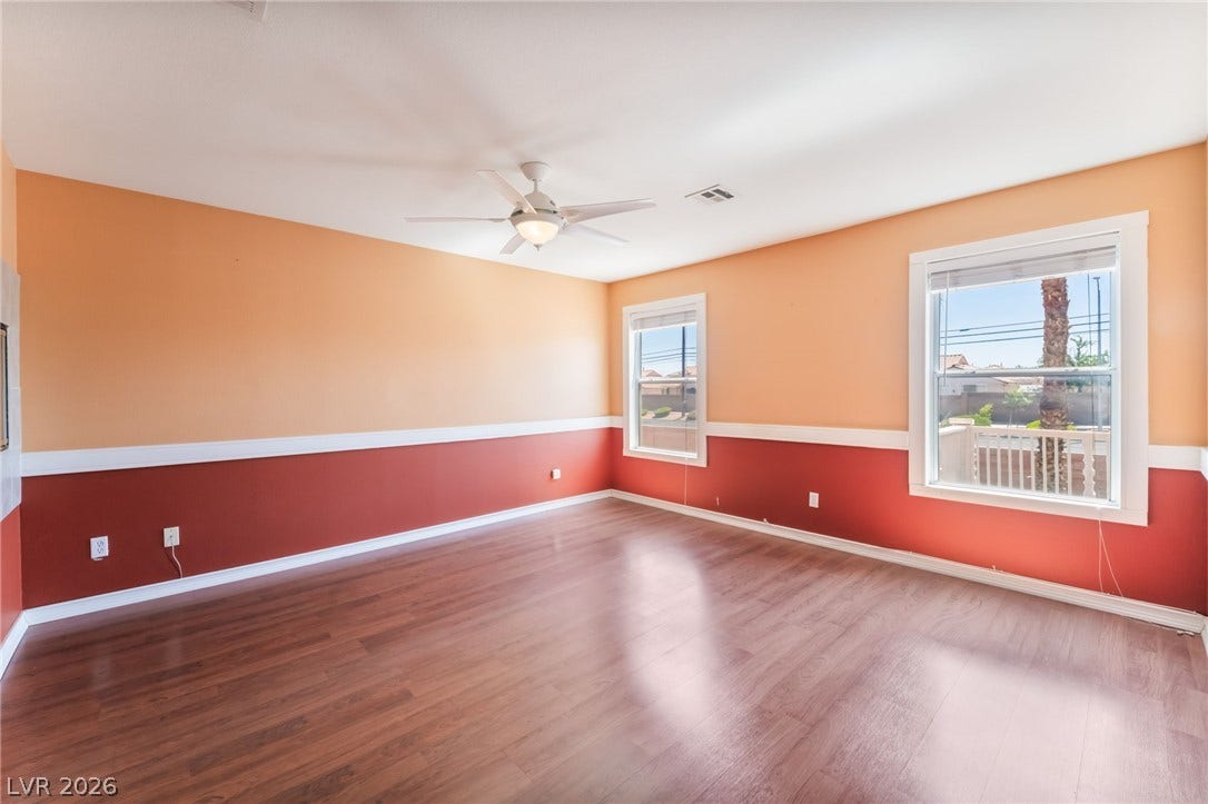 Rich wood flooring runs throughout this spacious living area detailed with traditional chair rail molding.