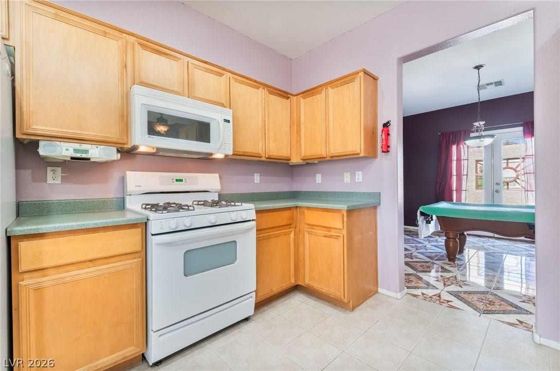 Ample wooden cabinetry and solid countertops define this highly functional culinary space.