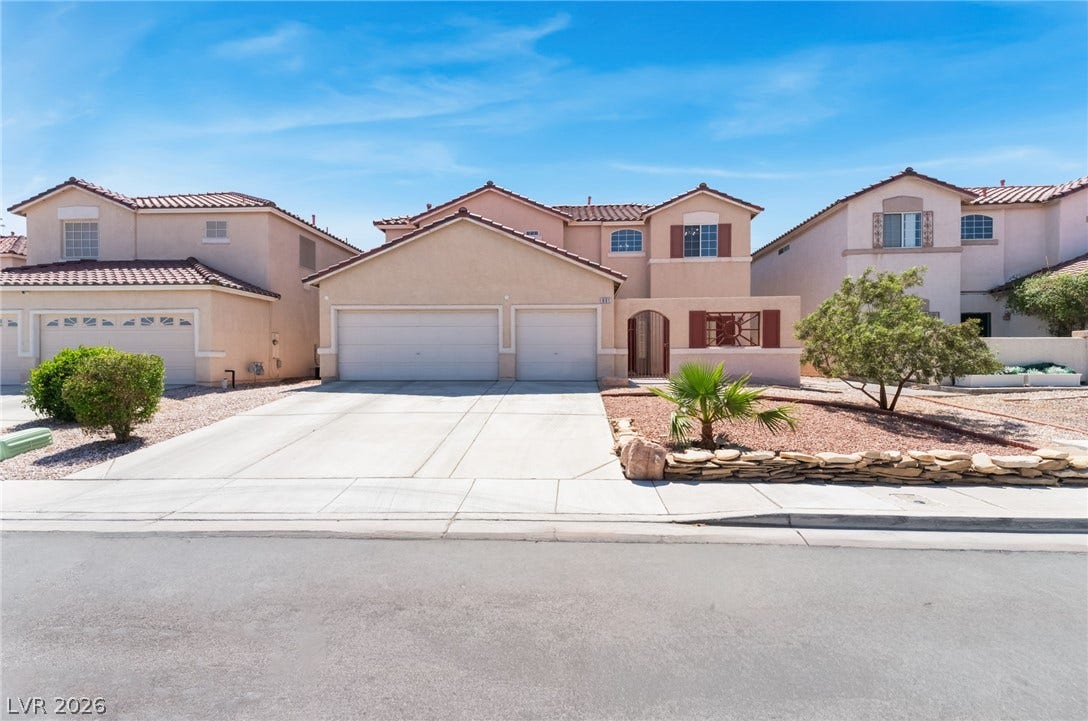 A classic stucco exterior features a tile roof and a spacious three-car garage.