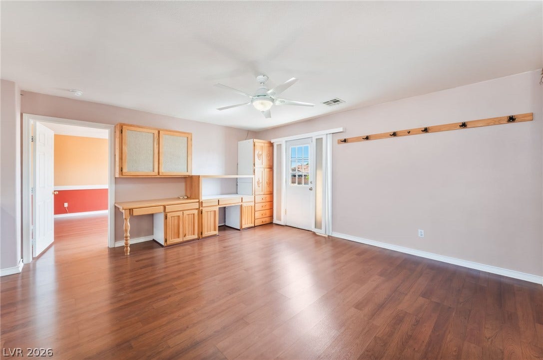 Rich wood-look flooring and custom built-in cabinetry define this versatile living space.