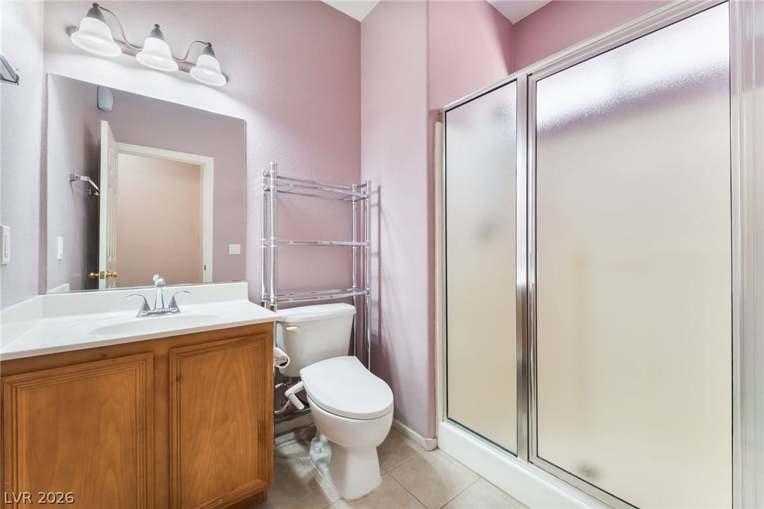 A wooden vanity and sliding glass shower doors highlight this well-appointed bathroom. Located on the first floor!