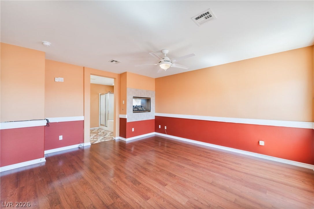 Warm wood flooring and a modern double-sided fireplace anchor this versatile living space.