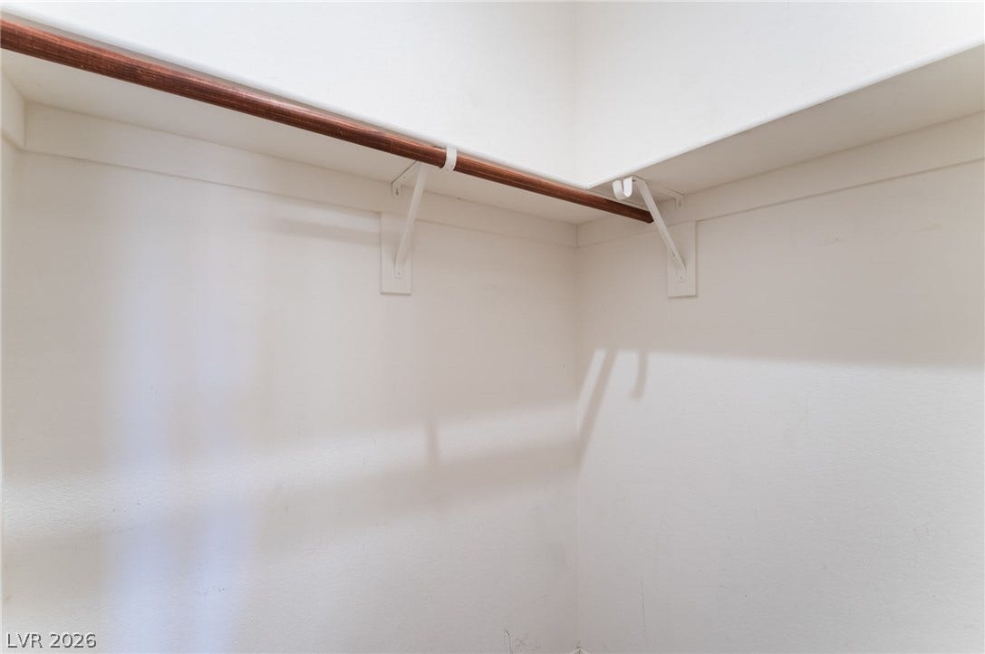 Ample shelving and sturdy hanging rods maximize storage potential in this walk-in closet.