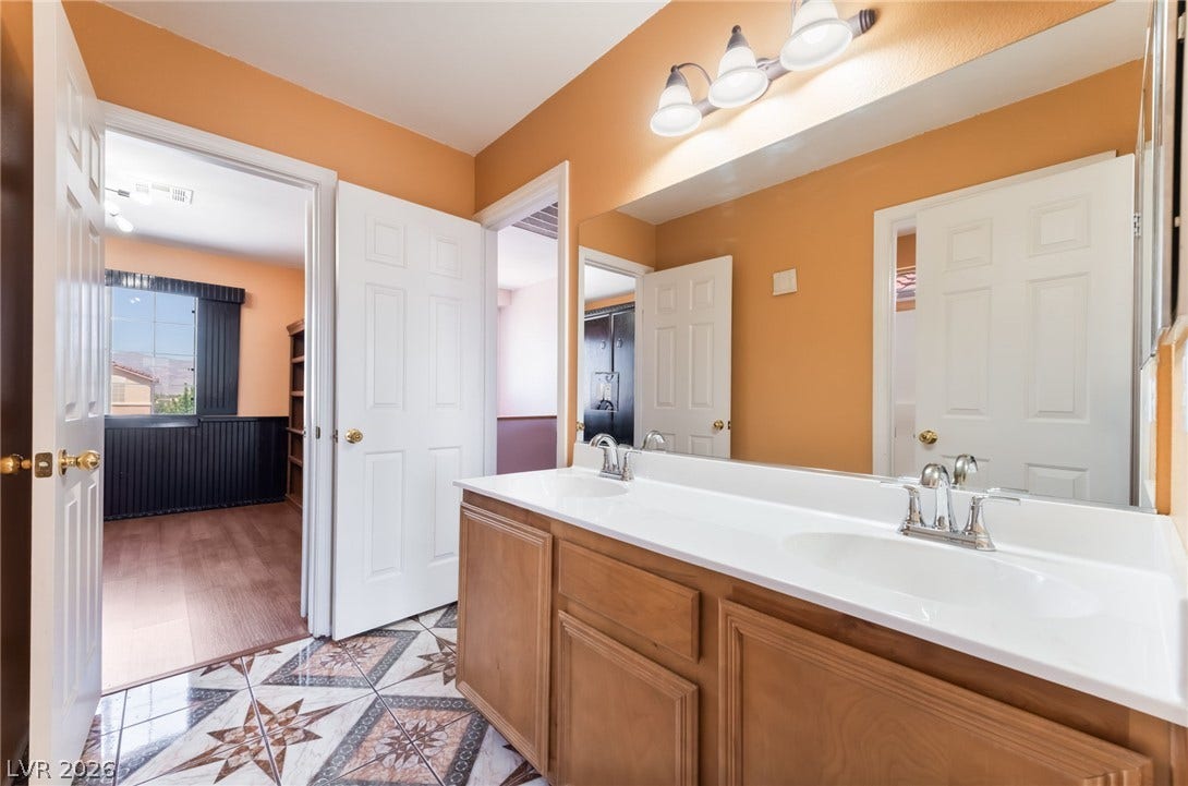 A spacious double vanity and patterned tile flooring define this functional secondary bathroom.