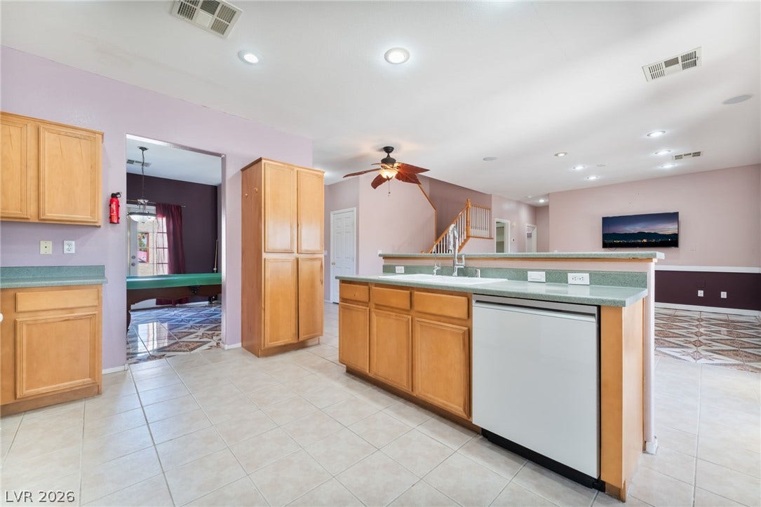 An open kitchen layout flows seamlessly into the main living spaces over durable tile flooring.
