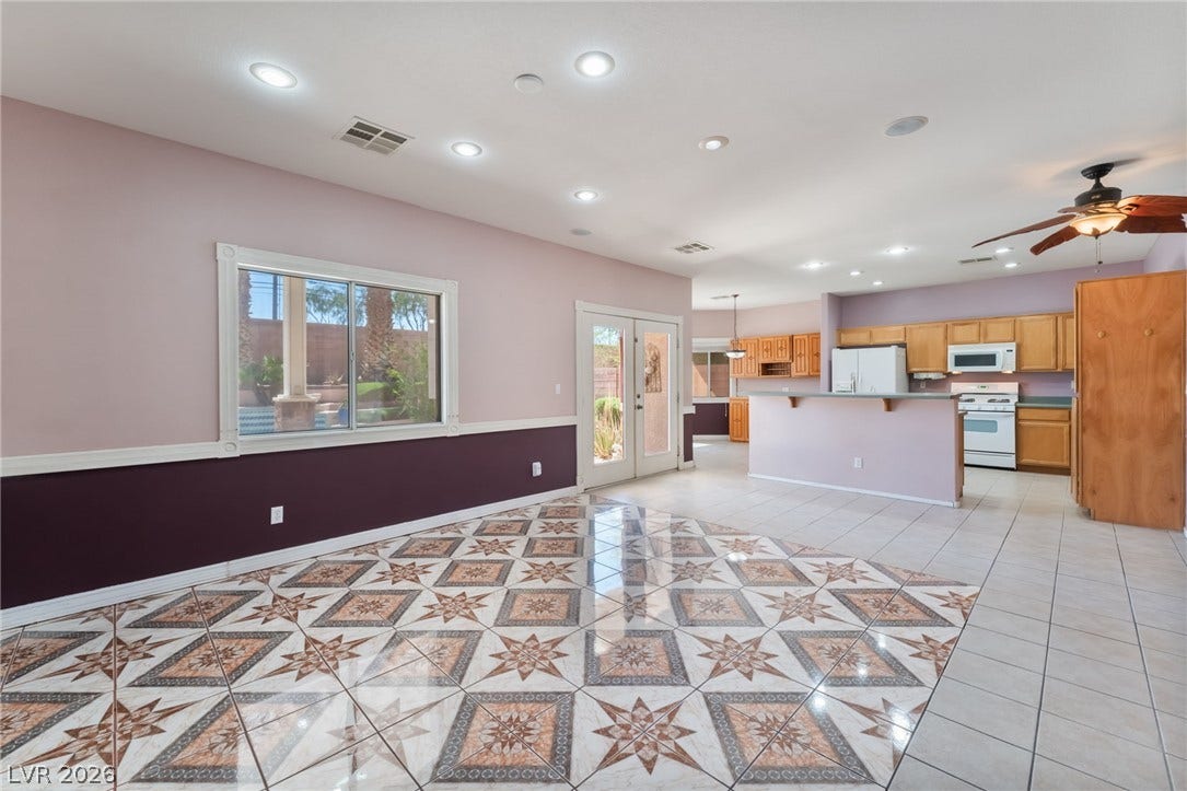 Ornate tiled floors and an open-concept layout flow seamlessly into the adjacent kitchen.