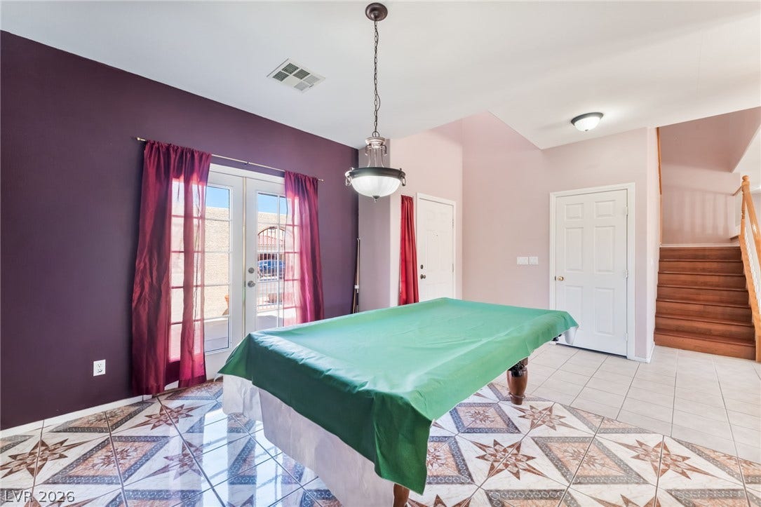 Gleaming tile floors and double glass doors define this versatile ground-floor recreation space.