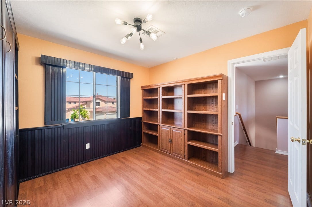 Gleaming hardwood floors and classic wainscoting define this versatile upper-level library space.