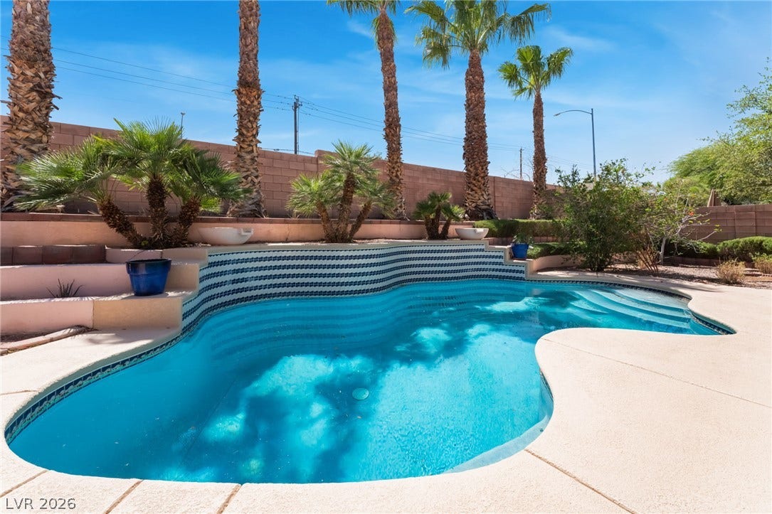 An inviting swimming pool serves as the centerpiece of this private, wall-enclosed backyard oasis.