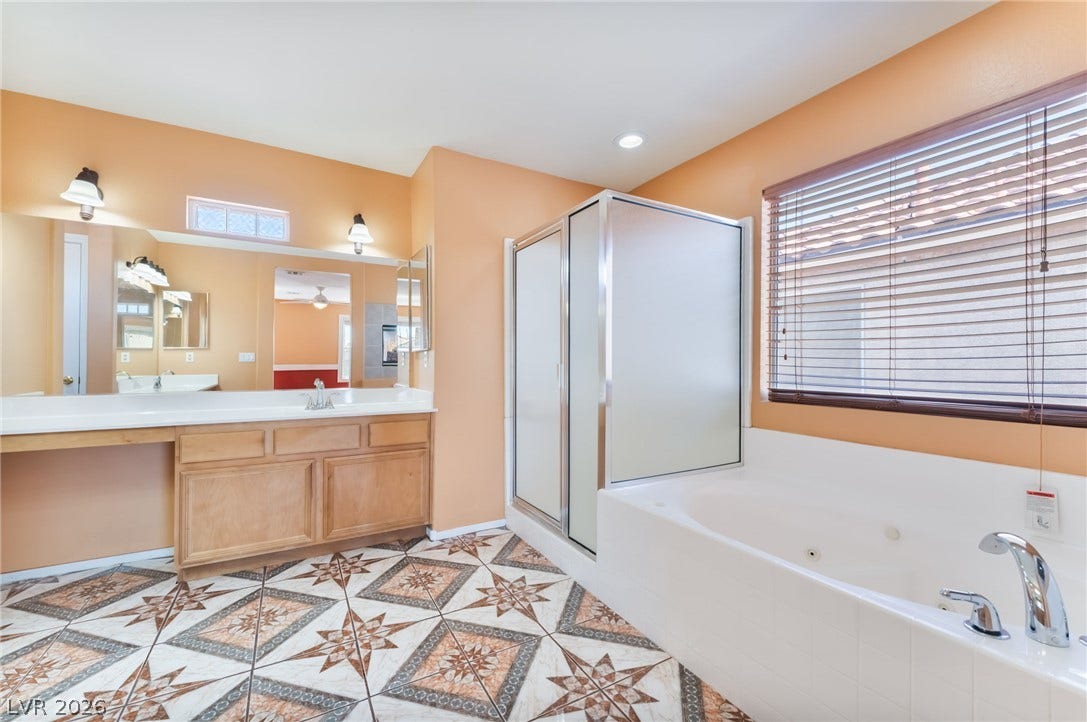 Ornate tiled flooring anchors a primary bathroom featuring a soaking tub and walk-in shower.