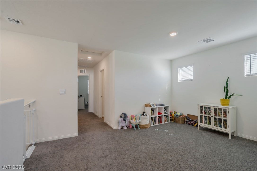 3428 Rush Avenue, Las Vegas, NV 89141 A spacious upper-level bonus space features comfortable carpeting and high-reaching ceilings.