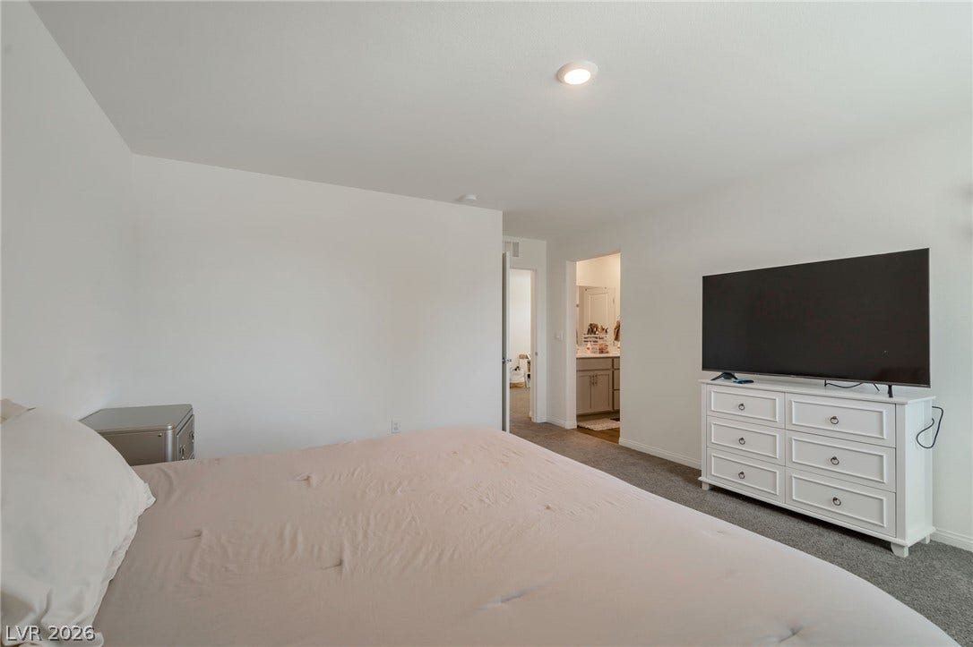 3428 Rush Avenue, Las Vegas, NV 89141 A minimalist bedroom displays clean white walls and soft carpet under recessed lighting.