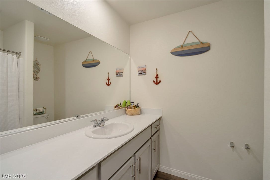 3428 Rush Avenue, Las Vegas, NV 89141 An expansive wall mirror enhances the sense of space above a crisp white vanity.