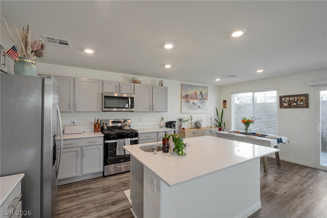 3428 Rush Avenue, Las Vegas, NV 89141 Gleaming quartz countertops and a spacious island anchor this modern open-concept kitchen.