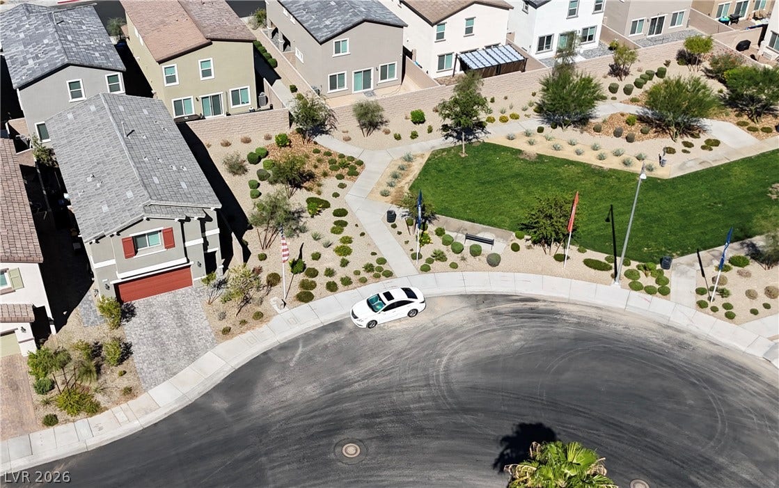 3428 Rush Avenue, Las Vegas, NV 89141 Neat suburban homes overlook a manicured green space along a curved residential street.
