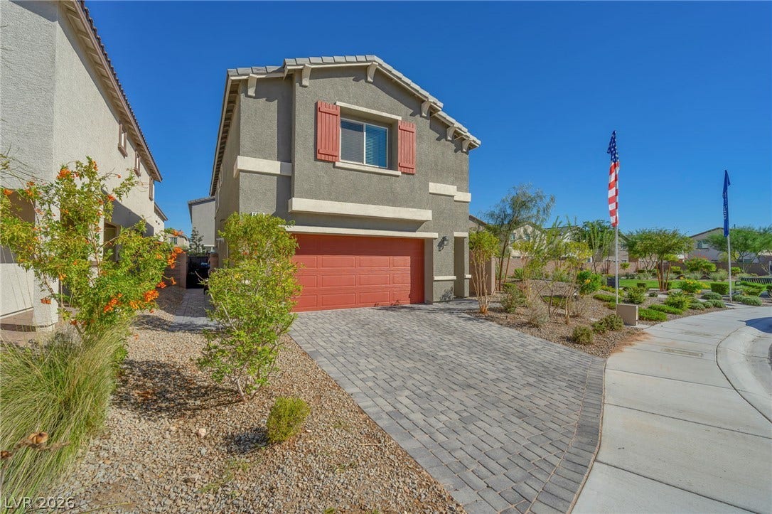 3428 Rush Avenue, Las Vegas, NV 89141 A paved driveway leads to the attached two-car garage of this multi-level stucco home.