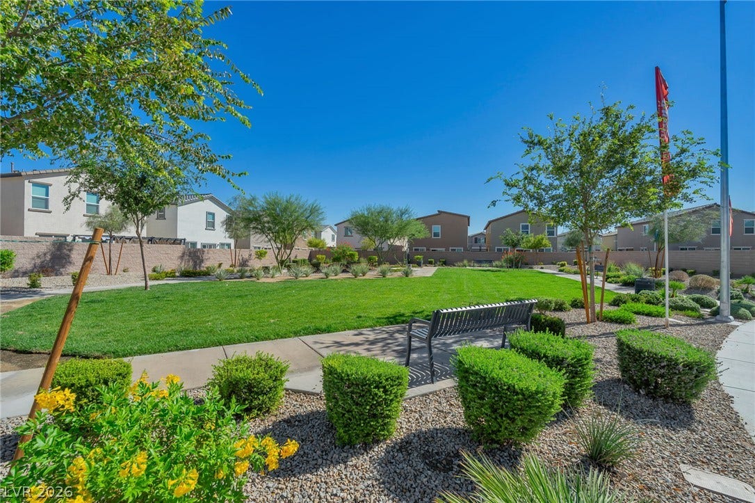 3428 Rush Avenue, Las Vegas, NV 89141 A paved walkway winds through manicured lawns and desert plantings in a central community park.
