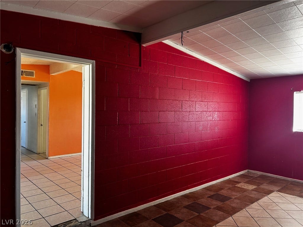 3708 Perliter Avenue, North Las Vegas, NV 89030 Exposed block masonry walls and tile flooring anchor this multi-room interior space.