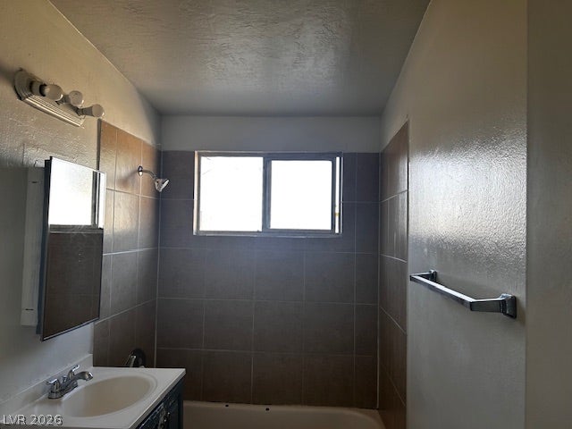 3708 Perliter Avenue, North Las Vegas, NV 89030 Tiled walls enclose the shower and tub combination next to a single vanity setup.