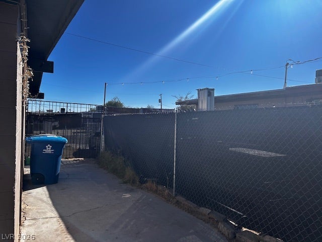 3708 Perliter Avenue, North Las Vegas, NV 89030 Secure fencing borders a paved concrete pathway along the side of the home.