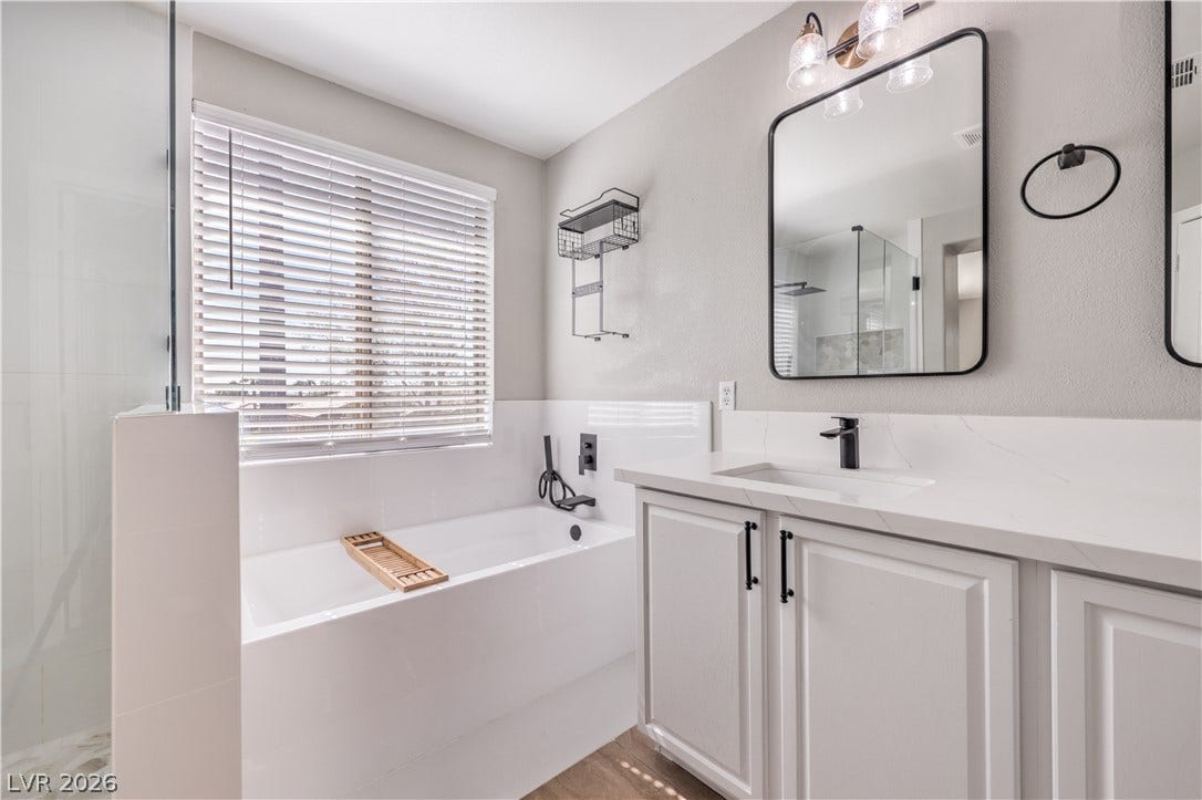 Clean lines and stone counters highlight this modern bathroom complete with a deep soaking tub.