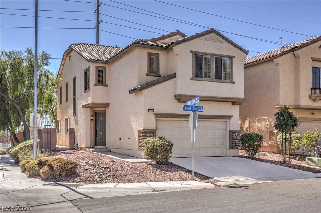 Mediterranean-inspired stucco exterior showcases a tile roof and stone accents on a corner lot.