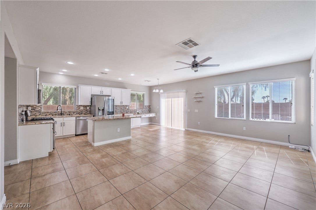 An open concept layout seamlessly connects the kitchen and living areas over tile flooring.