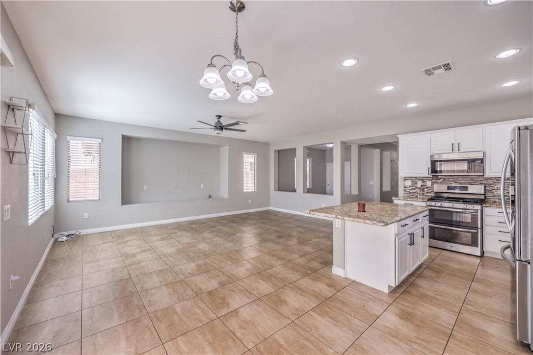 Tiled floors and recessed lighting enhance this airy kitchen and living area.