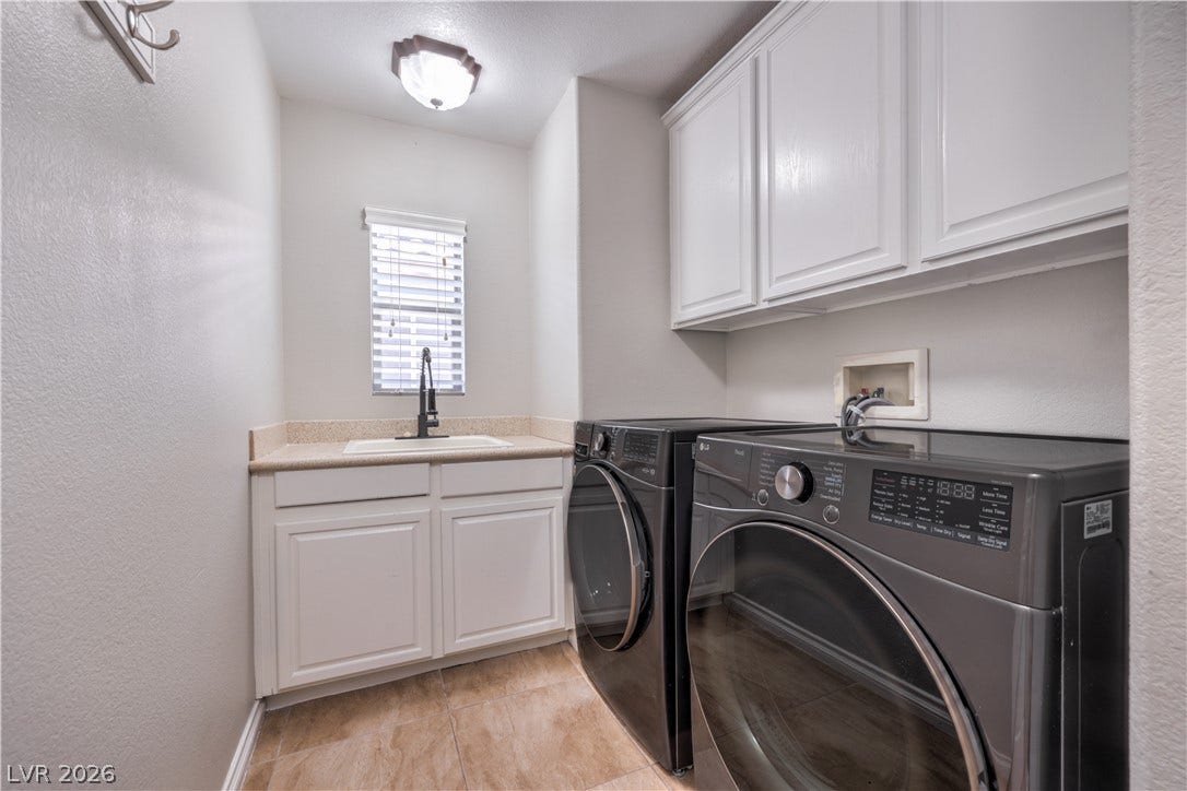 Ample built-in cabinetry and a functional utility sink define this practical workspace.