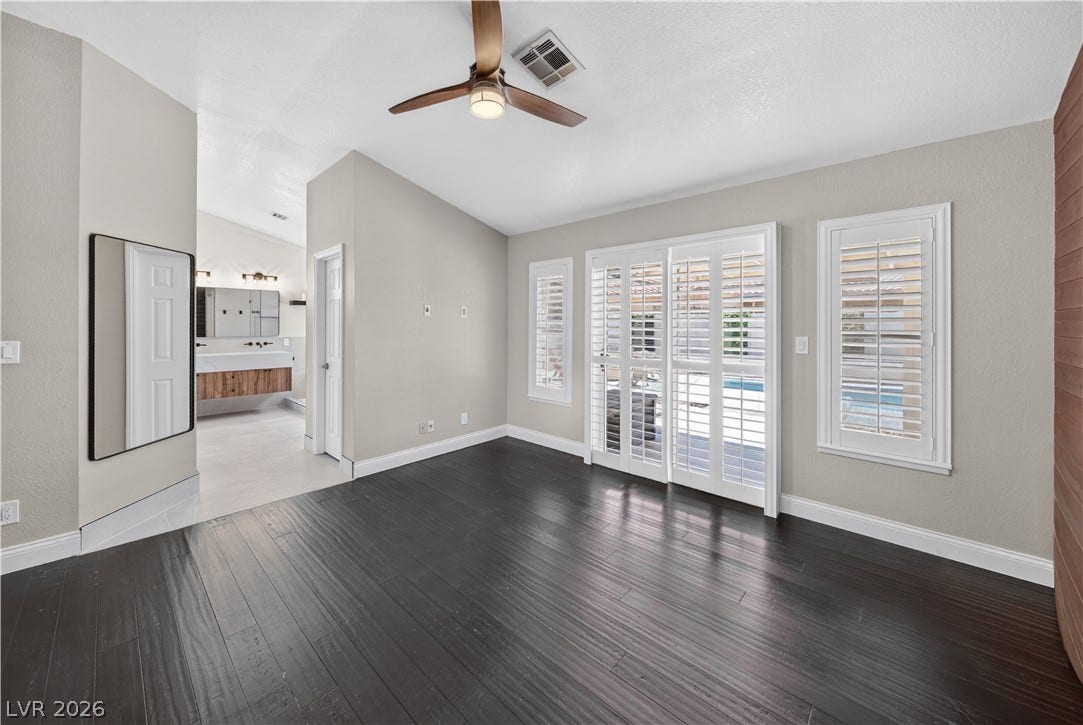 1740 Bluffs Drive, Henderson, NV 89014 Rich dark wood flooring contrasts beautifully with crisp white plantation shutters and vaulted ceilings.