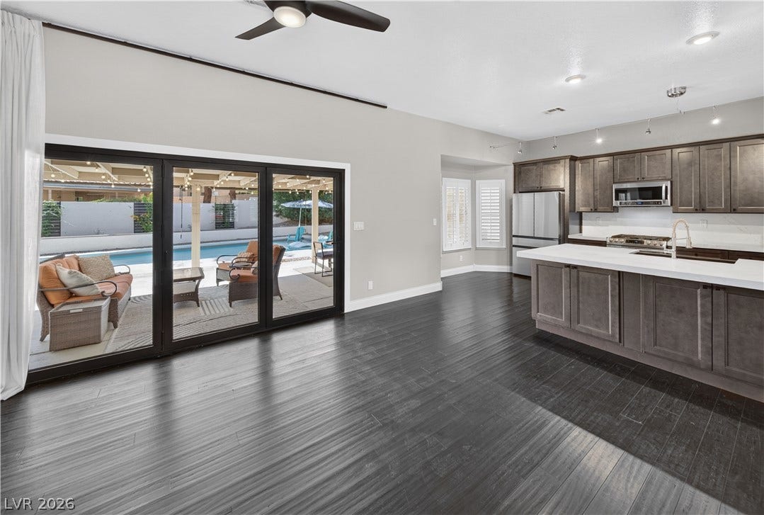 1740 Bluffs Drive, Henderson, NV 89014 Rich dark wood flooring anchors this open living space adjoining a modern kitchen.