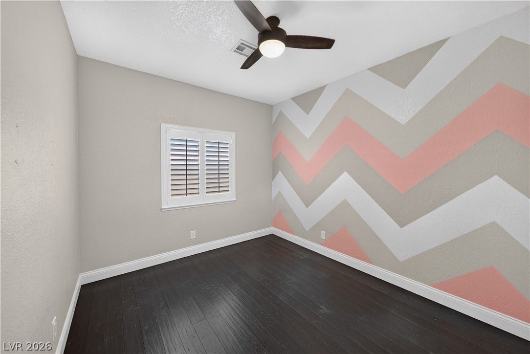 1740 Bluffs Drive, Henderson, NV 89014 Dark wood floors and a clean window establish a refined base in this versatile room.