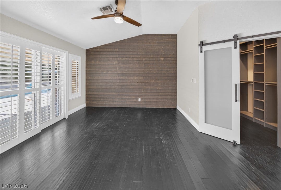 1740 Bluffs Drive, Henderson, NV 89014 Dark wood flooring and vaulted ceilings create a dramatic backdrop in this spacious bedroom.