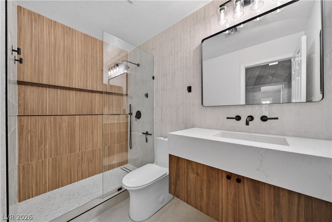 1740 Bluffs Drive, Henderson, NV 89014 Modern finishes define this washroom featuring a glass-enclosed shower and sleek vanity.