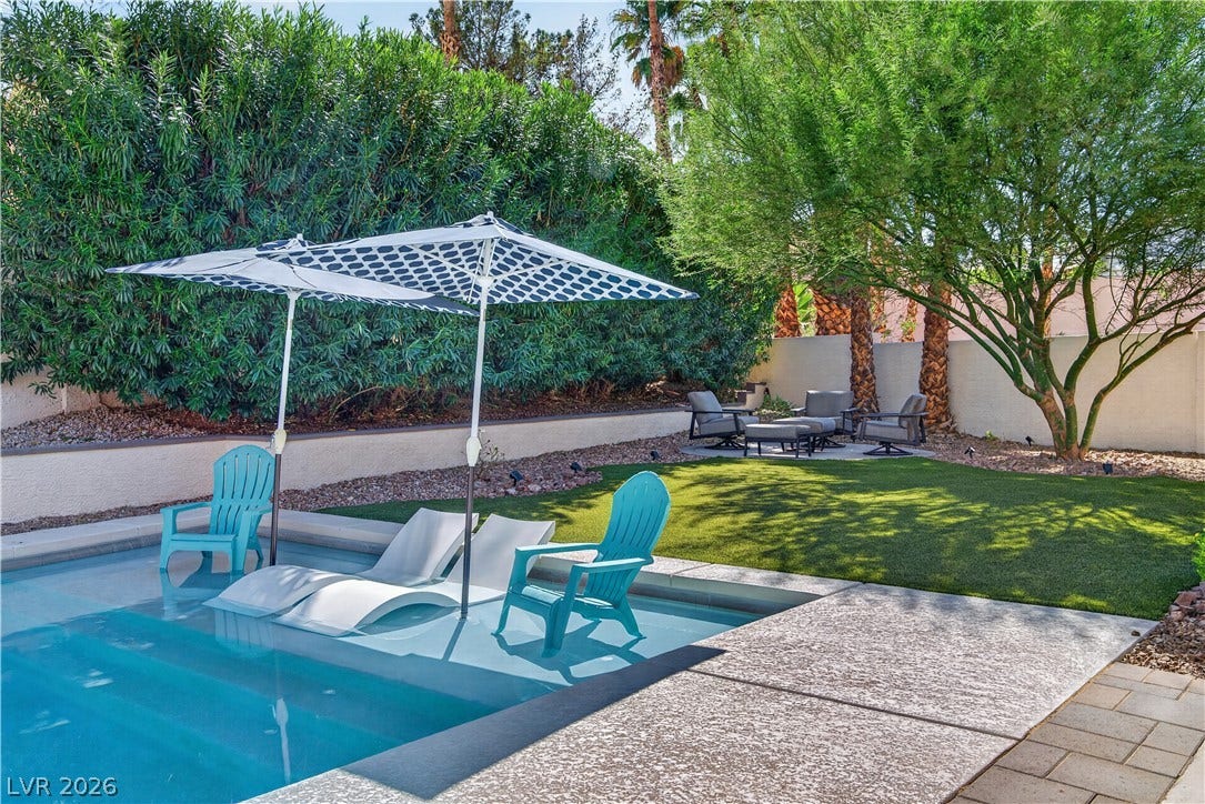 1740 Bluffs Drive, Henderson, NV 89014 Mature trees and a manicured lawn frame this relaxing poolside retreat.