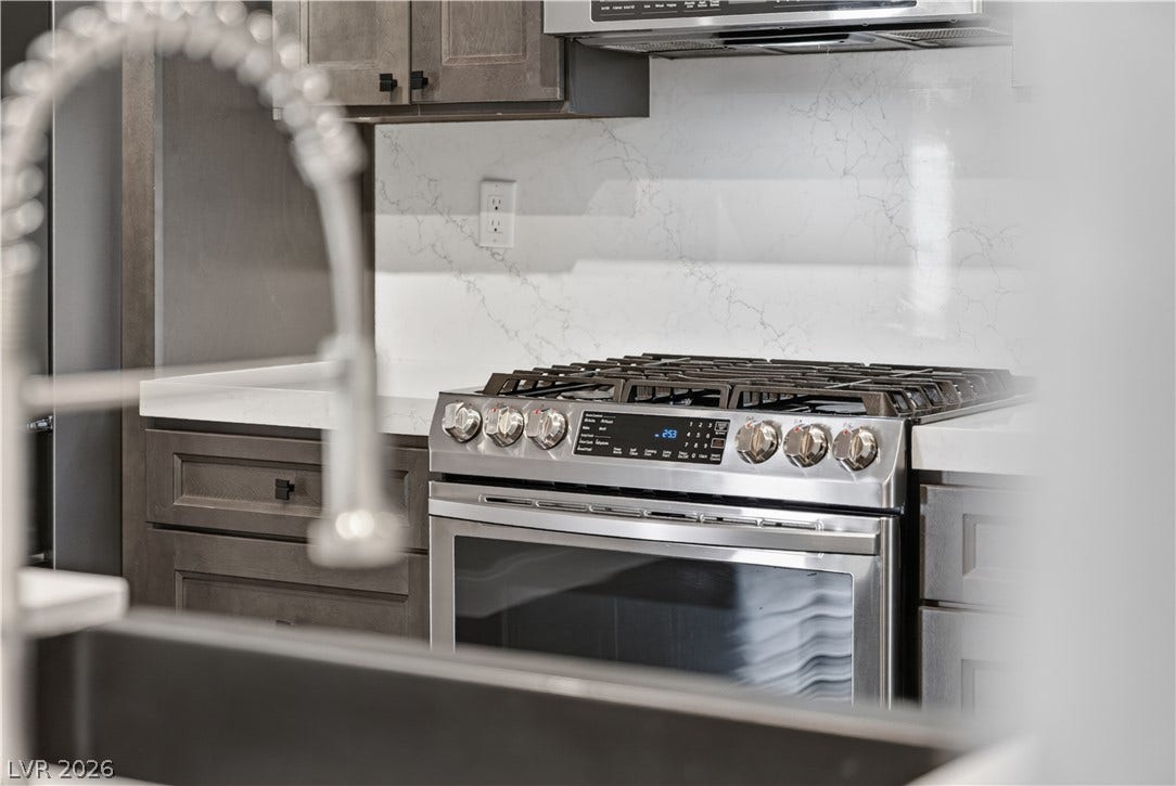 1740 Bluffs Drive, Henderson, NV 89014 Polished stone counters and premium cabinetry frame a high-end stainless steel range.